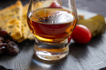 Whiskey and cheese pairing, tasting whisky glasses and plate with sliced crumbly old blue stilton and blue shropshire cheeses, Great Britain food and drink