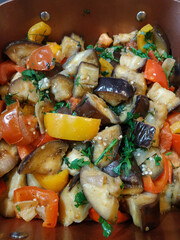 Eggplant, tomatoes, and peppers sauteed with herbs in a pan healthy vegan dinner