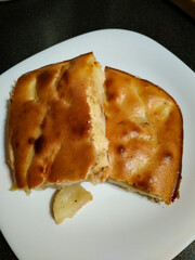 Sliced apple pie showing filling on white plate
