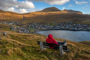 Man is looking panorama view at Sandavagur village, Faroe Island