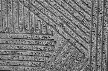 gray background, photo shows texture of decorative plaster on concrete wall close-up