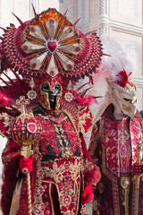 Venice, Italy - People dressed in carnival masks are photographed by tourists in the scenery of the ancient Venetian palaces