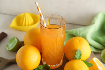 Glass of fresh orange juice with mint and fruits on white background
