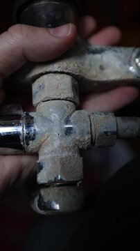 A rusty water faucet. Outdated plumbing. A broken faucet with lime coating.