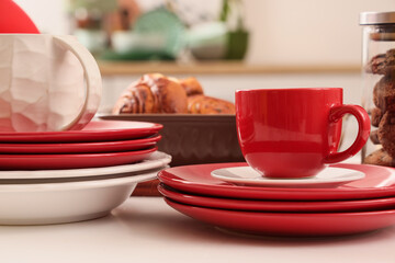 Different clean dishes and fresh pastry on table in kitchen