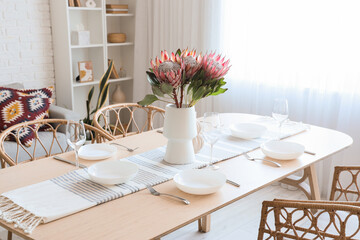 Table setting with protea flowers in dining room