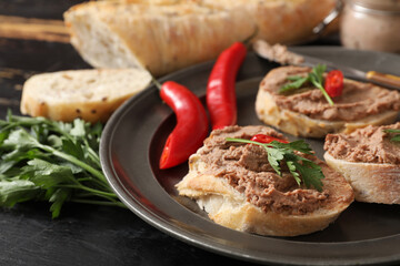 Plate with toasts, tasty pate, chilli peppers and parsley on dark wooden background