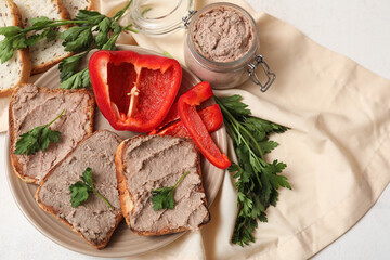 Plate with toasts, jar of tasty pate, parsley and bell pepper on light background