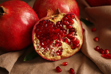 Fresh ripe pomegranates and seeds on napkin, closeup