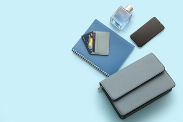 Composition with stylish female handbag, modern mobile phone, credit cards and perfume on color background
