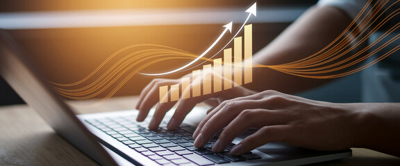 Hands typing on laptop keyboard, overlaid with upward trending graph and glowing lines, symbolizing business growth and digital success