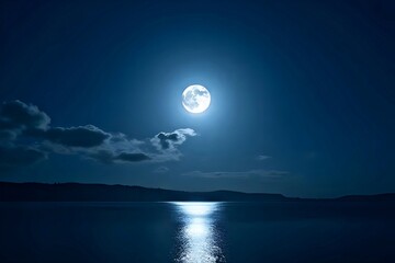 A full moon shining brightly in the night sky, its reflection glistening on the calm lake below.