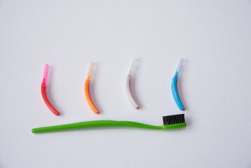 Toothbrushes and interdental brush on the white background. Dental and orthodontic concept.