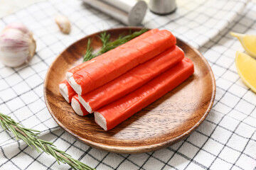 Wooden plate with tasty crab sticks and rosemary on napkin, closeup © Pixel-Shot