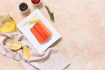 Plate with tasty crab sticks and different spices on beige background © Pixel-Shot