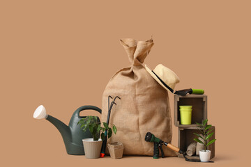 Gardening supplies and sack on beige background