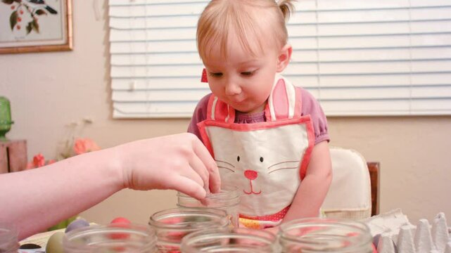Little Girl making Easter Eggs with cute Aprin on