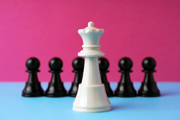 White queen chess in front of black pawn on pink background