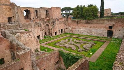 Rome, Italy - 4.4.2018: Ancient ruins of the Palatino featuring intricate wall structures and lush greenery in a serene setting with visitors exploring its historical significance