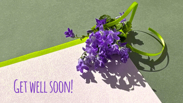 Purple flowers with a Get well soon! message on a textured background