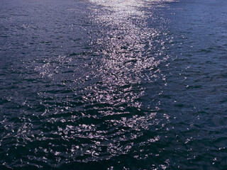 Ocean water glittering surface with sun reflections 