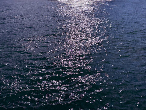 Ocean water glittering surface with sun reflections 