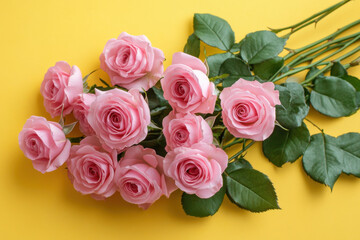 Obraz premium Bouquet of pink roses lying on a yellow background