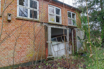 Abandoned Brick Building with Broken Windows and Damaged Doorway
