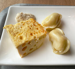 Omelette and dumplings in a white plate. Close-up