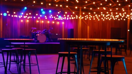 Vibrant indoor venue with illuminated string light, empty tables, and a stage setup for live music