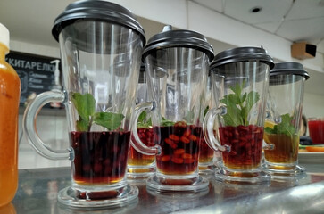 Colorful beverages with mint leaves on display in a cafe setting during the afternoon