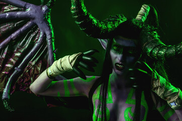 Fototapeta premium Demon Hunter Demon Cosplay on Black Background in Green Light