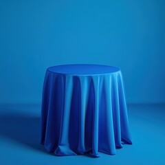 Blue draped fabric on round table against blue background.