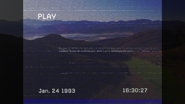 VHS-style animation overlaying date and time on mountain landscape scene