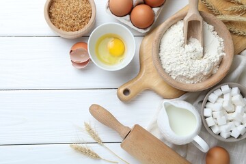 Rolling pin and ingredients for dough on white wooden table, flat lay. Space for text