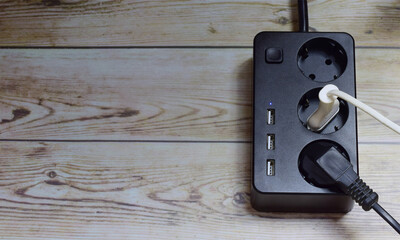 Plug connected to an extension cord, concept of electricity consumption.	