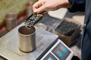 Careful measurement of colorful firework components in a factory setting prepares for an exciting night of visual celebration