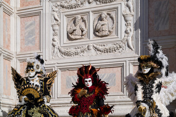 Venice, Italy - People dressed in carnival masks are photographed by tourists in the scenery of the ancient Venetian palaces