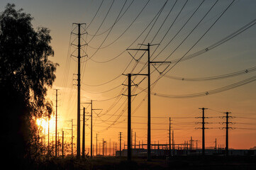 Dense alignment of transmission towers and utility poles carry high-voltage power lines across an...