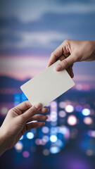 Two hands exchange a blank off-white card against a blurred city lights background, symbolizing connection, communication, or business exchange