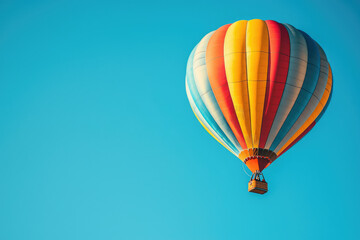 Fototapeta premium A vibrant hot air balloon soars against a clear blue sky, a breathtaking scene of adventure and freedom.