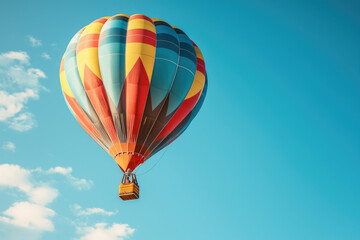 Fototapeta premium A vibrant hot air balloon ascends against a clear blue sky, creating a stunning visual spectacle.