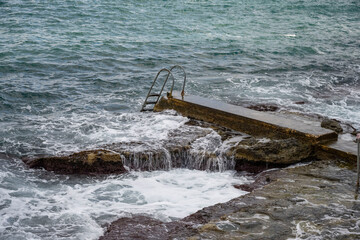 Fototapeta premium High Angle Shot of a Sea Waves Crashing on the Rocks. Rocks by the Sea North of Malta.