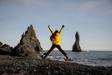 A tourist jumoing at Reynisfjara beach in South Iceland © Christina Pichler