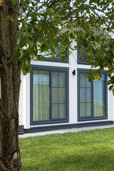 Country house in minimalist Scandinavian style. Garden and lawn maintenance. Vertical photo