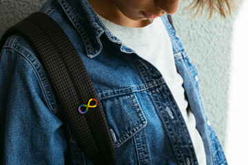 Teenage boy with autism infinity rainbow symbol sign. World autism awareness day, autism rights movement, neurodiversity, autistic acceptance movement