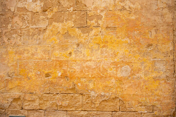 Processed collage of ancient yellow block wall texture. Background for banner, backdrop or texture for 3D mapping.A rectangular slab of light sandstone against the background of stone fragments as the