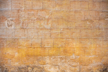 Processed collage of ancient yellow block wall texture. Background for banner, backdrop or texture for 3D mapping.A rectangular slab of light sandstone against the background of stone fragments as the