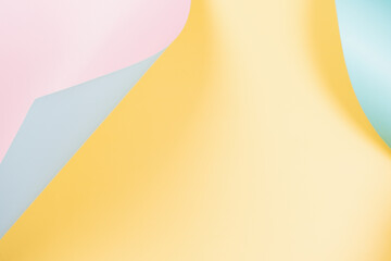 Abstract wave of yellow, pastel pink and light blue paper. Creative geometric curved solid color paper with light and shadows. Abstract geometry background with copy space