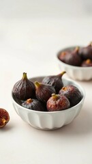 Obraz premium Ripe purple fig fruit in a white ceramic bowl on light pastel background Harvest and healthy eating